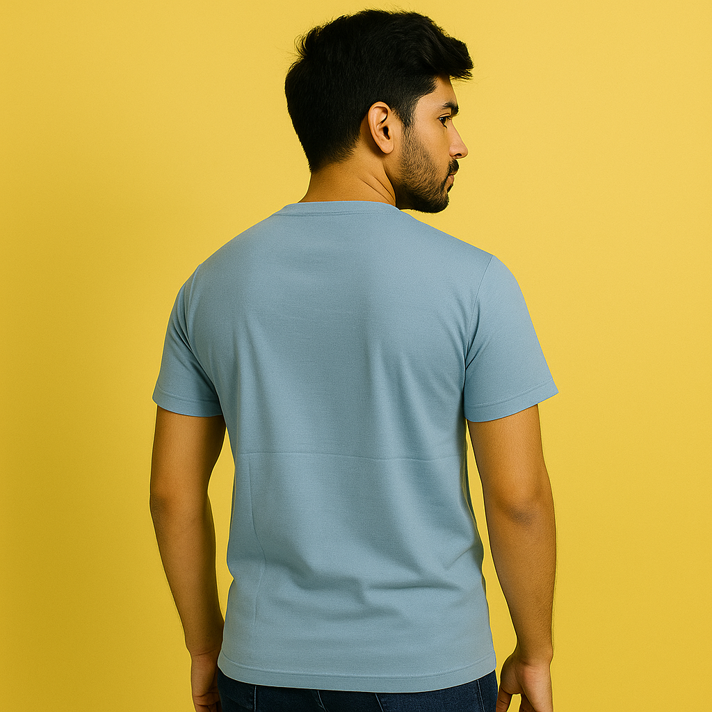 Back view of a man wearing a misty turquoise cotton spandex unisex t-shirt against a yellow background.